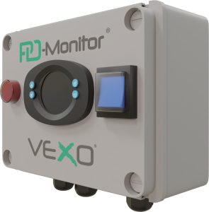 A VEXO PD-Monitor device, featuring a compact, rectangular grey enclosure with a circular control interface, blue function buttons, a red emergency stop button, and a blue display screen. The unit is designed for monitoring and managing fluid dynamics in building systems.